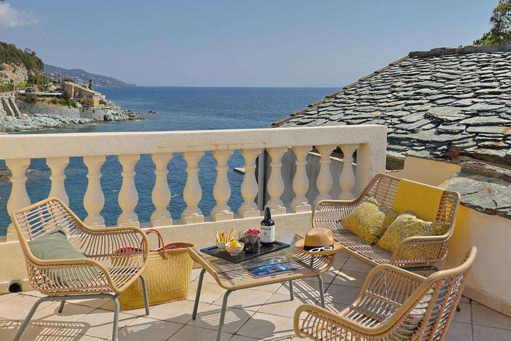 a balcony with chairs and a table and the ocean at Casa Di U Mare in San-Martino-di-Lota
