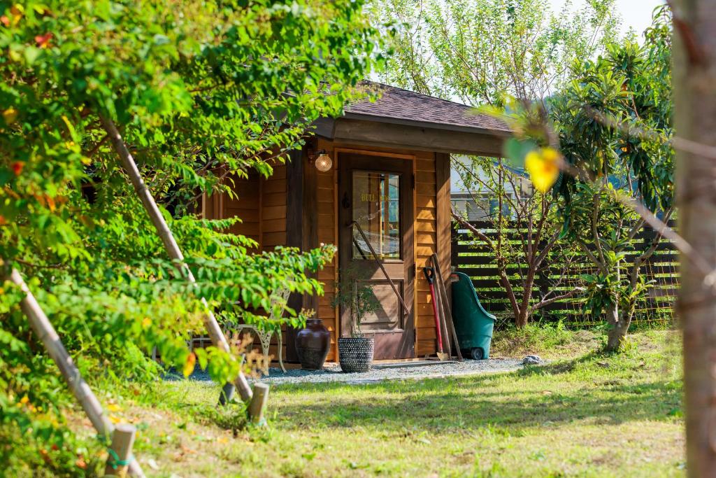 a small wooden cabin with a dog in front of it at ヴィラかほく by Nook's Kitchen in Kami