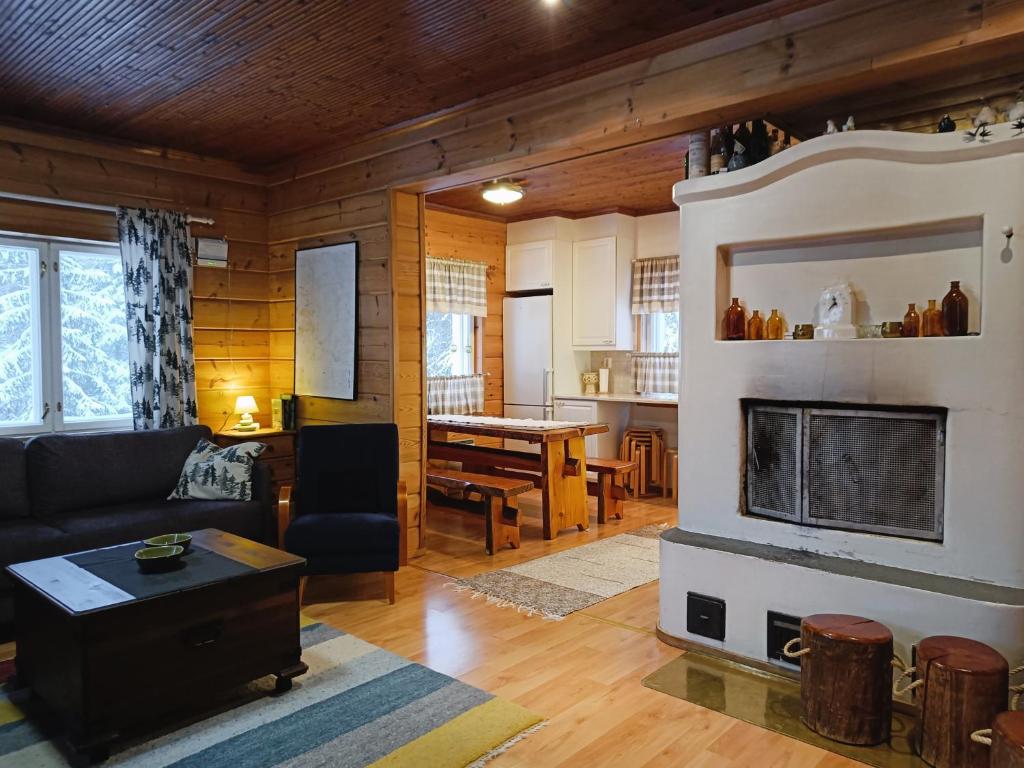 un soggiorno con divano e camino di Kuusirinne a Syöte