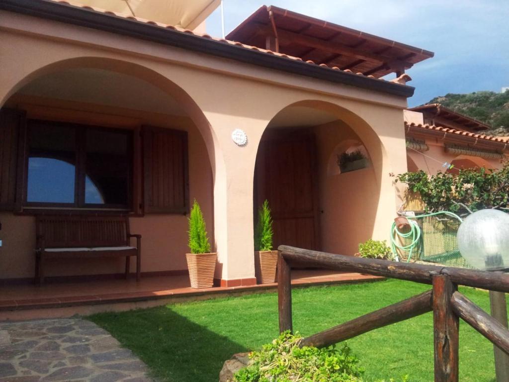 una casa con un porche con un banco en el patio en Villa Lobe, en Riva dei Pini