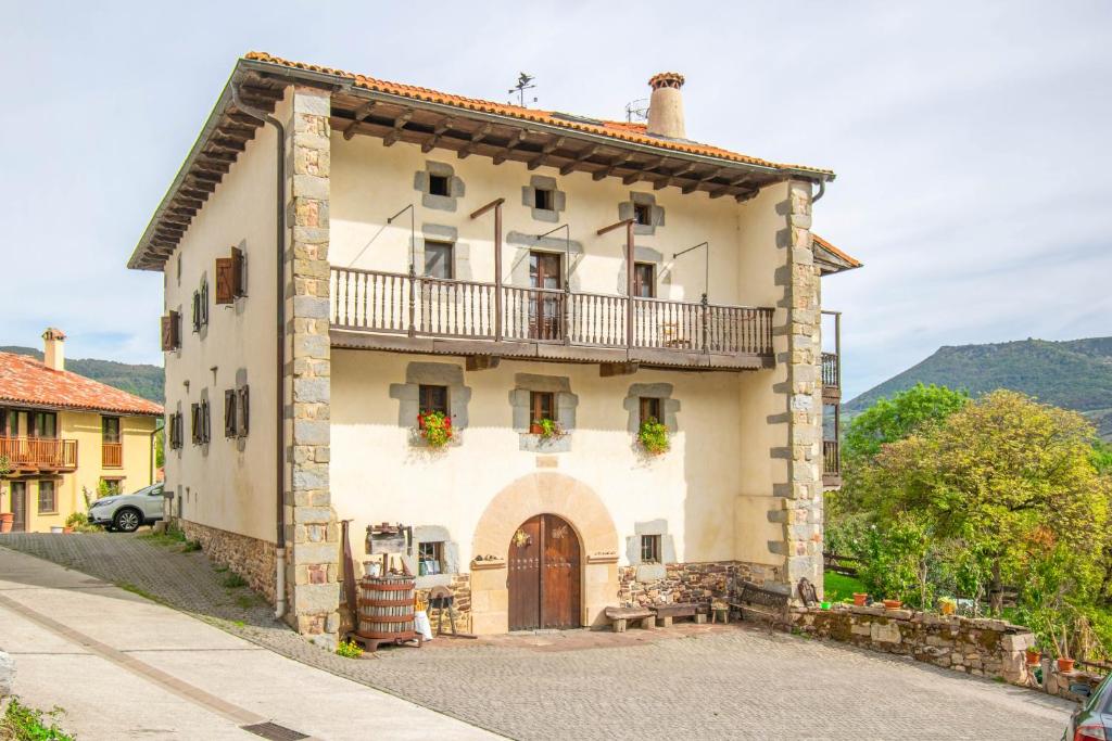 a large building with a balcony on top of it at Espacioso apartamento en el Pirineo Navarro in Saragüeta