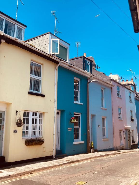 a row of colourful houses on a street at Fisherman's Cottage - Harbour Close, Pub Closer, Sea Views if You Look Hard in Brixham