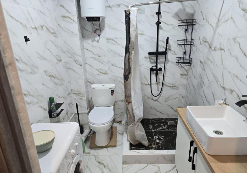 a white bathroom with a toilet and a sink at TESTkg in Cholpon-Ata