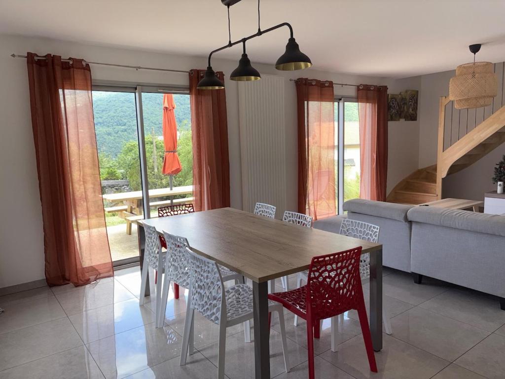 ein Esstisch und Stühle in einem Wohnzimmer in der Unterkunft Maison Soulom in Soulom