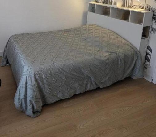 a bed with a gray comforter in a bedroom at Les Morèses in Amélie-les-Bains-Palalda