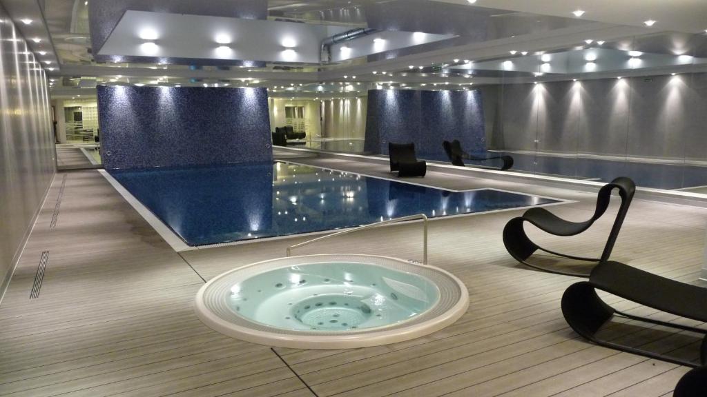 a swimming pool with a tub in the middle of a room at Apartament Koga Waterlane in Gdańsk