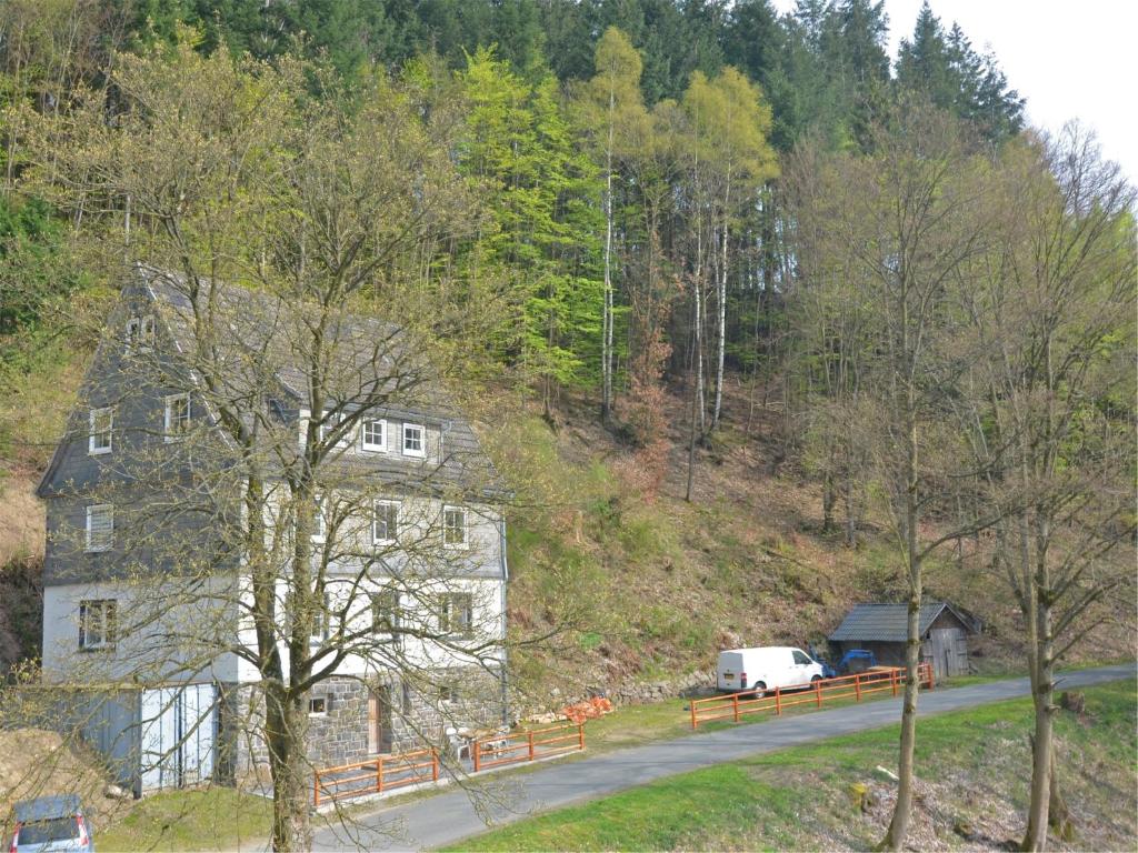 a house and a white van parked on a road at Villa with Sauna in Liesen in Hallenberg