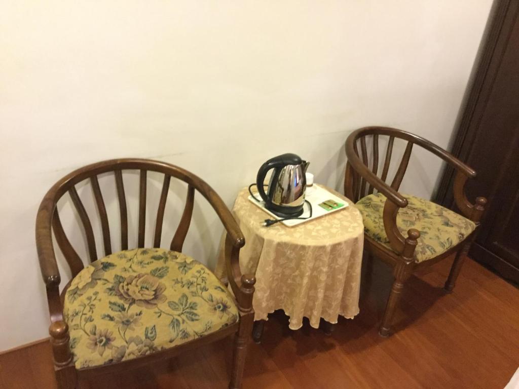 two chairs and a table with a tea kettle on it at 闕麒景觀民宿Chill Villa B&amp;B in Puli