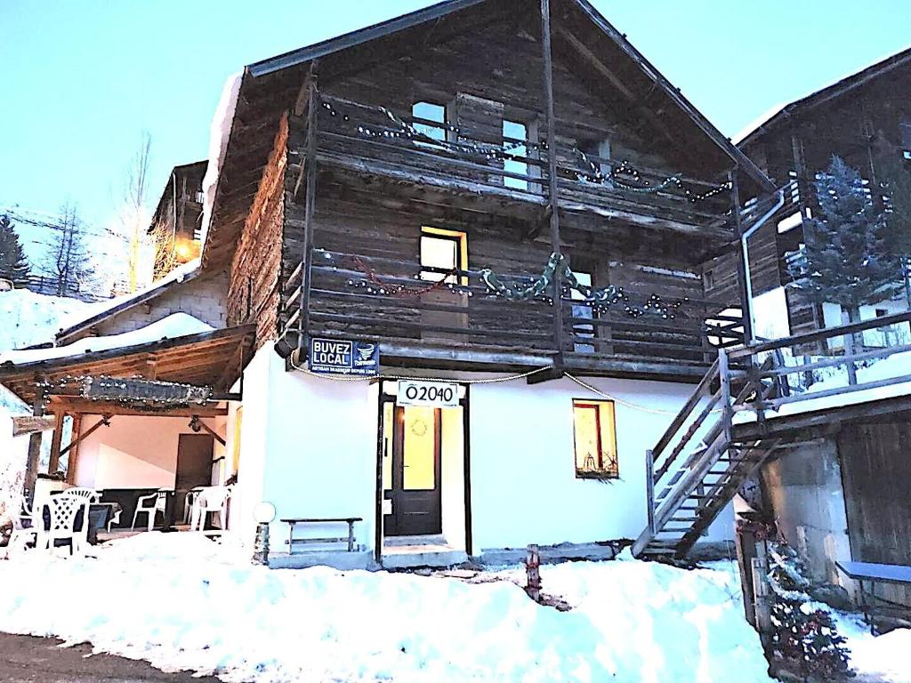 a wooden building with a porch in the snow at CASA-2040 Family-Friendly Chalet Saint-Véran in Saint-Véran