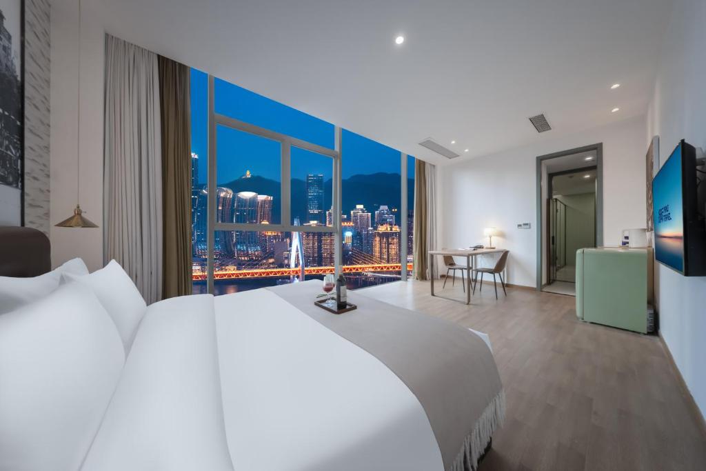 a bedroom with a large bed and a large window at YANG TRAVEL Hotel 重庆解放碑洪崖洞店 in Chongqing