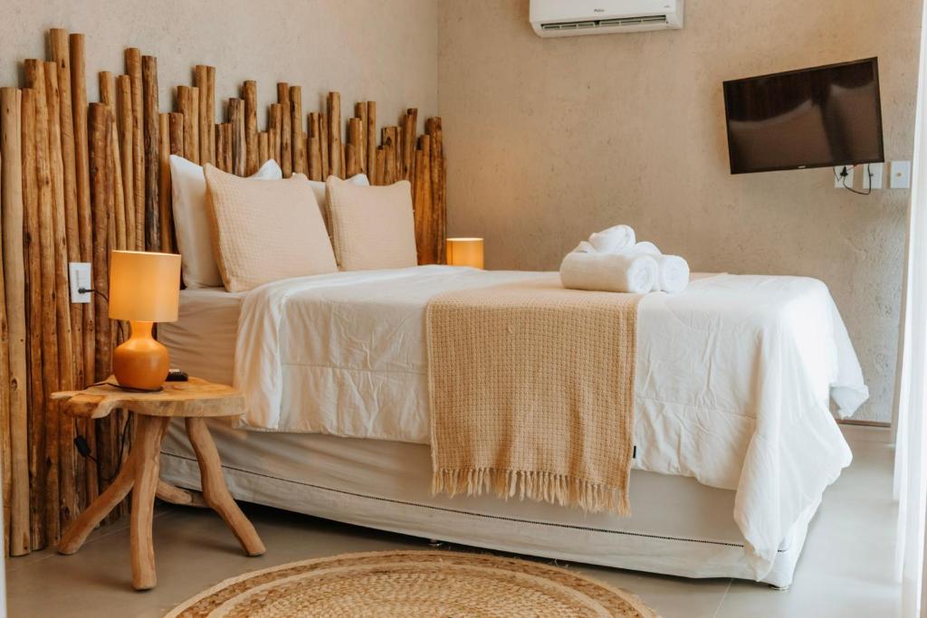 1 dormitorio con 1 cama con sábanas blancas y TV en Casa Nina Milagres, en São Miguel dos Milagres