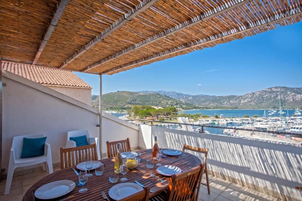 Una mesa en un balcón con vista a la playa. en Casa Sainte-Anne, en Saint-Florent