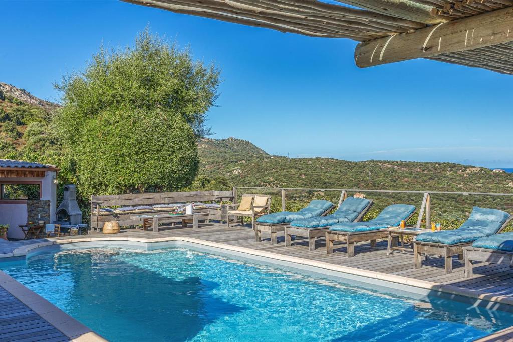 een zwembad met blauwe stoelen en een tafel bij Villa A Surgenta in Monticello