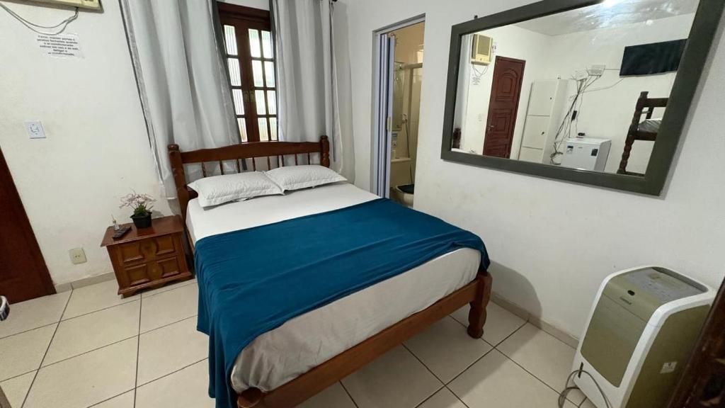 a bedroom with a bed and a mirror in a room at Hostel Arraial in Arraial do Cabo