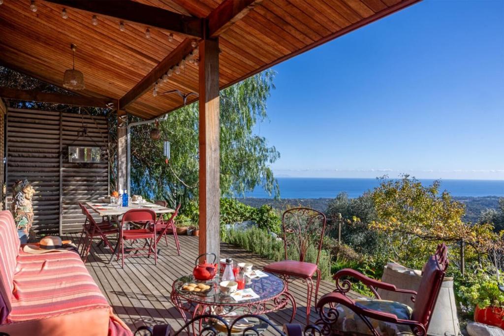 eine Terrasse mit Tisch und Stühlen auf einem Deck in der Unterkunft Maison E Tre Petre in Valle-di-Campoloro