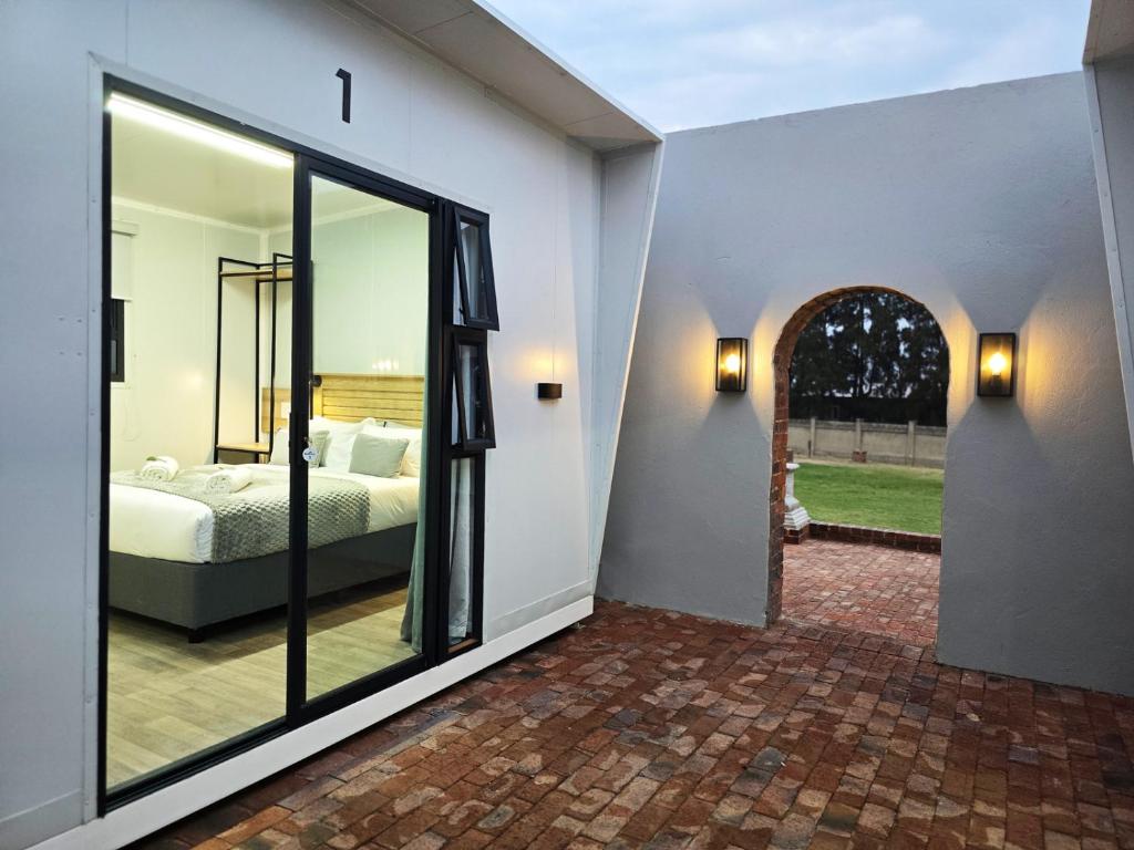 a bedroom with a bed and a large glass door at Beds Inn Midrand in Midrand
