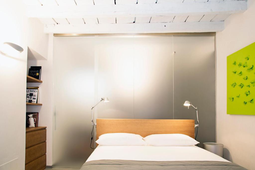 a bedroom with a bed with a wooden headboard at Solferino Suite in Milan