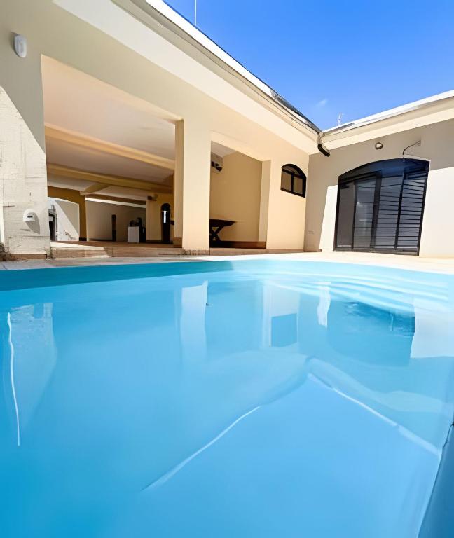 an empty swimming pool in front of a house at Casa com piscina, área gourmet e espaço p/ festas in Ribeirão Preto