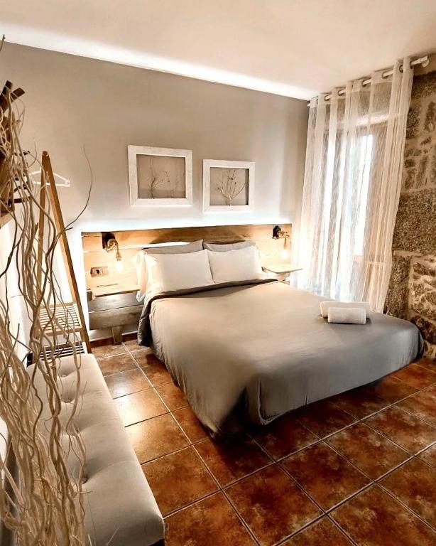 een slaapkamer met een groot bed en een raam bij Casa As Fontes in Porqueirós