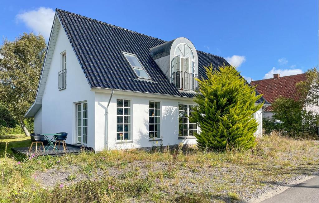 a white house with a black roof at 2 Bedroom Nice Home In Harpelunde in Harpelunde
