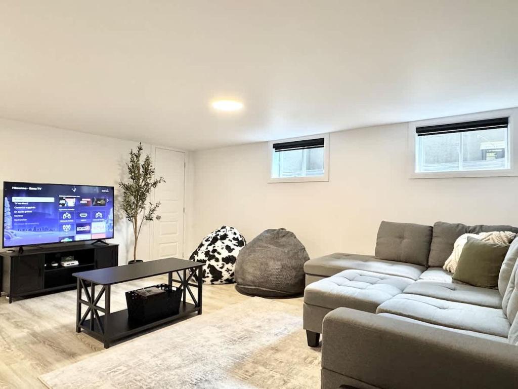 ein Wohnzimmer mit Couch und Flachbildfernseher in der Unterkunft Ste-Foy urban area - 4 bedrooms - Spa - EV chrger in Québec