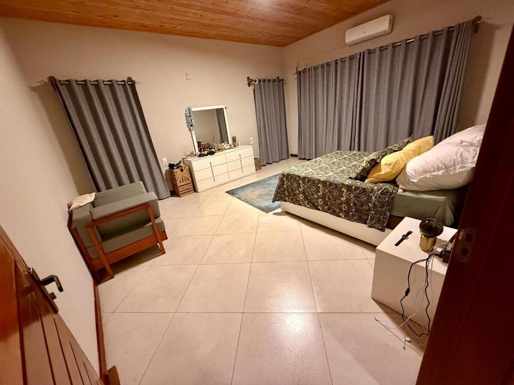 a bedroom with a bed and a tiled floor at Rustic, Contemporary, Cozy with Home Office in Pemba