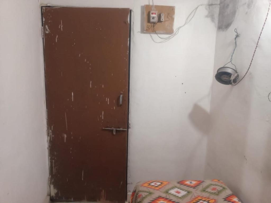 浦那Singh-Sadan PG HomeStay的白色房间的棕色门上有一个座位