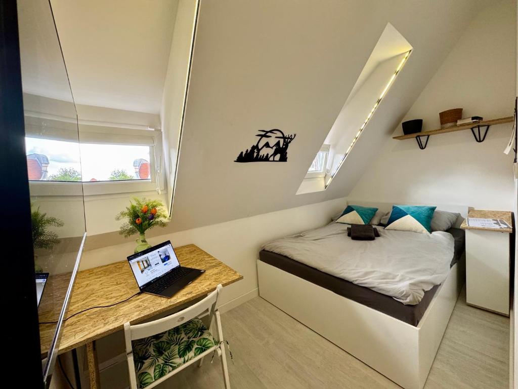 a small room with a bed and a desk with a laptop at 36-Maniana - DeerRest Apart in Jelenia Góra
