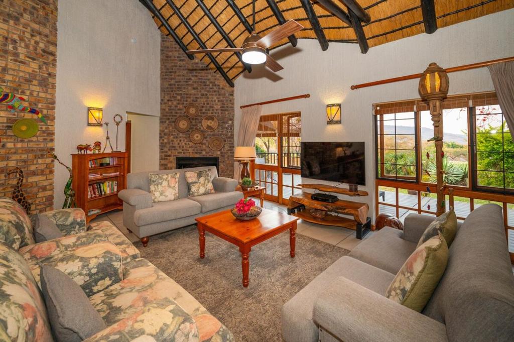 Kruger Park Lodge Unit No 304 في هازيفيو: غرفة معيشة مع أريكة وتلفزيون وطاولة
