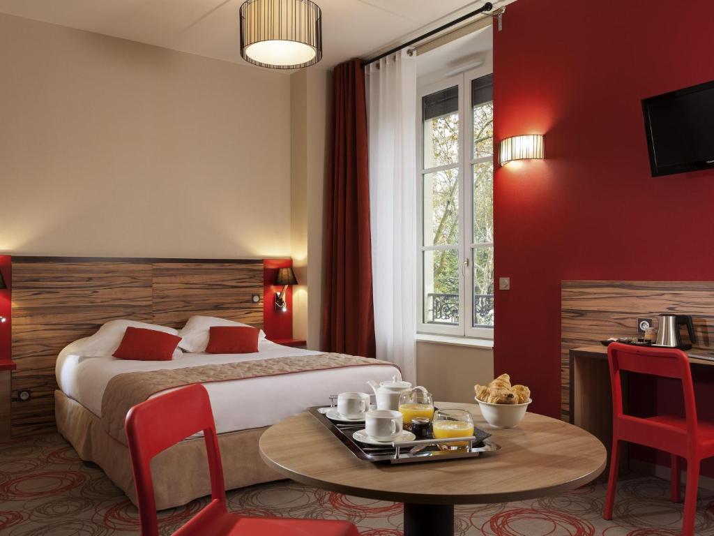 a hotel room with a bed and a table with food on it at Aparthotel Adagio Lyon Patio Confluence in Lyon