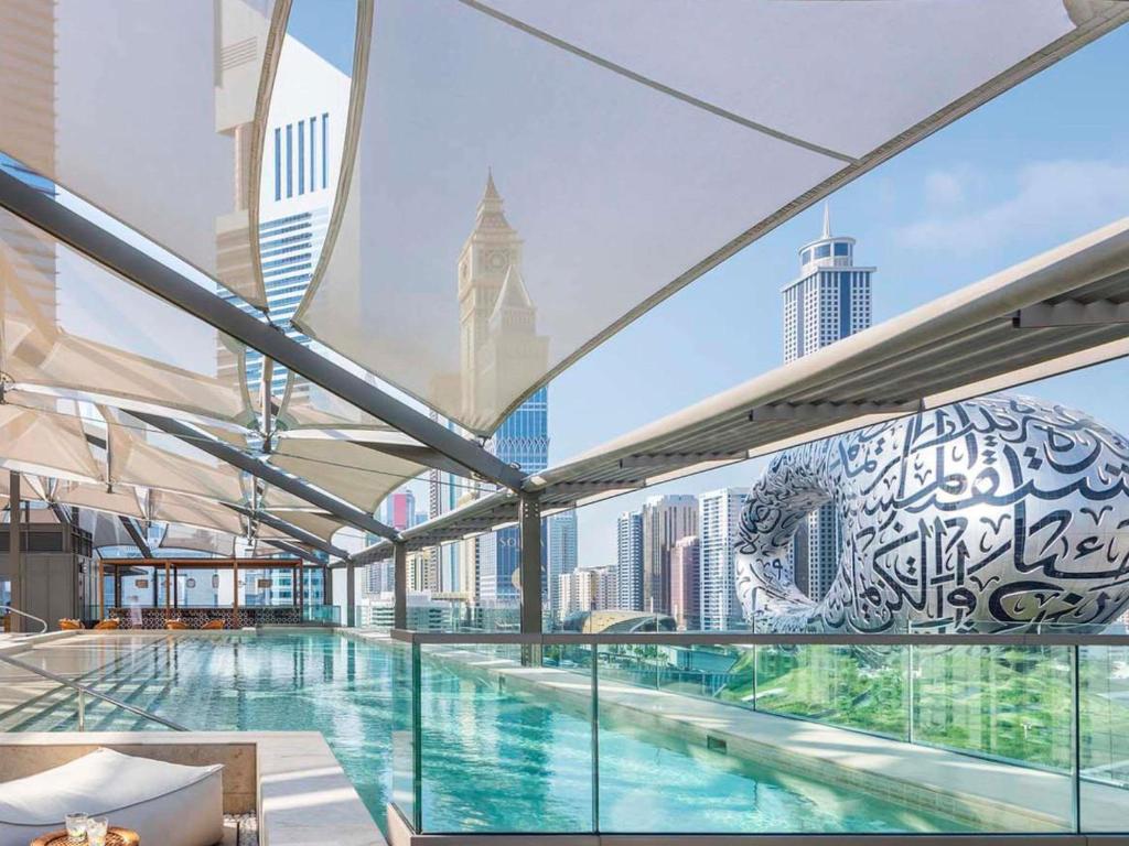 een groot zwembad in een gebouw met uitzicht op de stad bij 25hours Hotel Dubai One Central in Dubai
