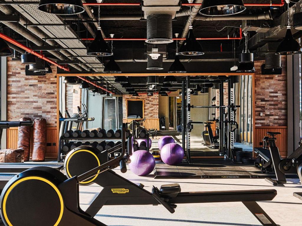 een fitnessruimte met verschillende loopbanden en machines bij 25hours Hotel Dubai One Central in Dubai