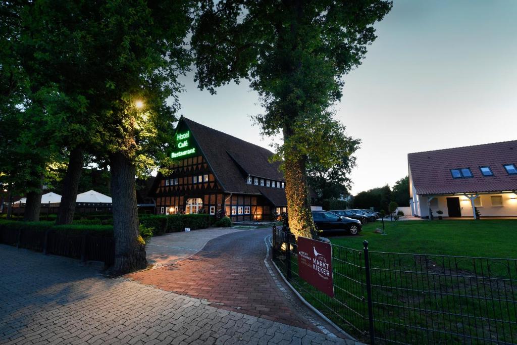 un grand bâtiment en bois avec un toit en gambrel dans l'établissement Hotel Marktkieker, à Großburgwedel