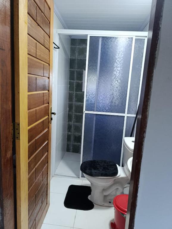a bathroom with a toilet and a glass shower at Apêzinho de Luxo Morros in Morros