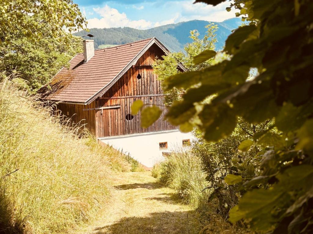 a barn with a wooden roof on a hill at Almliesl KREM-753 in Eisentratten