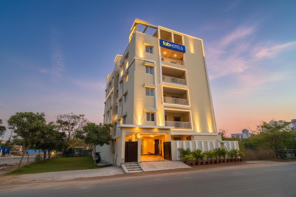a tall white building with a sign on it at FabHotel RK Suites - Nr US Consulate, Financial District in Hyderabad