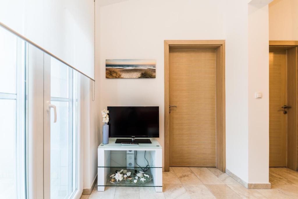Televízia a/alebo spoločenská miestnosť v ubytovaní Apartmani Villa Adriatic