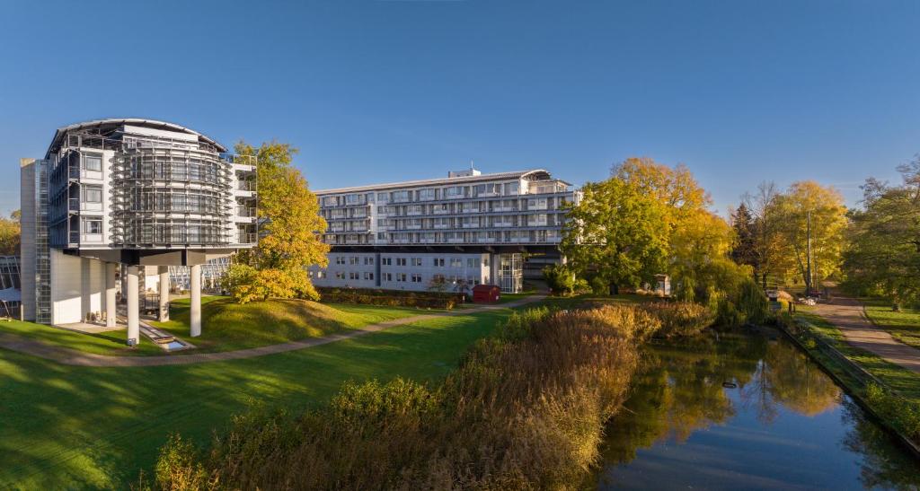 a building next to a river next to a building at Kongresshotel Potsdam am Templiner See in Potsdam
