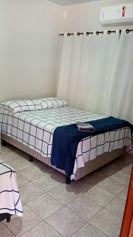 a bed sitting in a room with a window at Hotel Vale do Sol in Valparaíso
