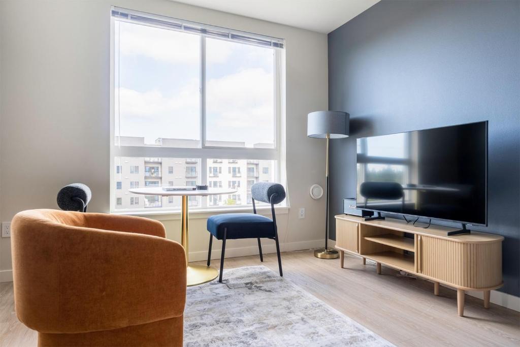 a living room with a television and a chair at Blueground Meridian Park view nr Shoreline Park SEA-932 in Shoreline
