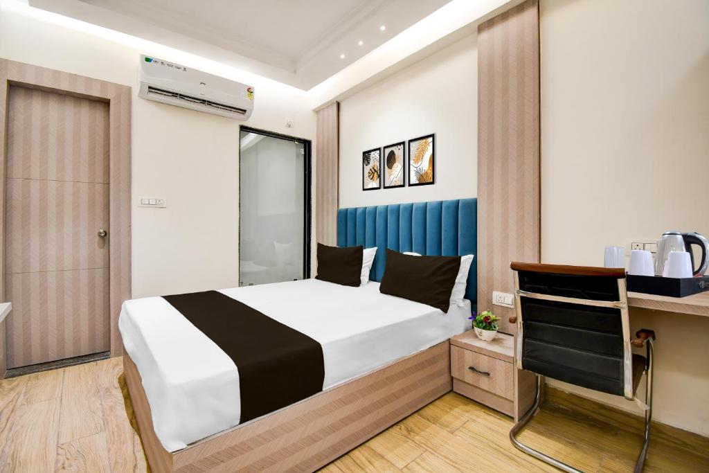 a bedroom with a bed and a desk with a tv at Collection O Bairhana Road Prayagraj in Prayagraj