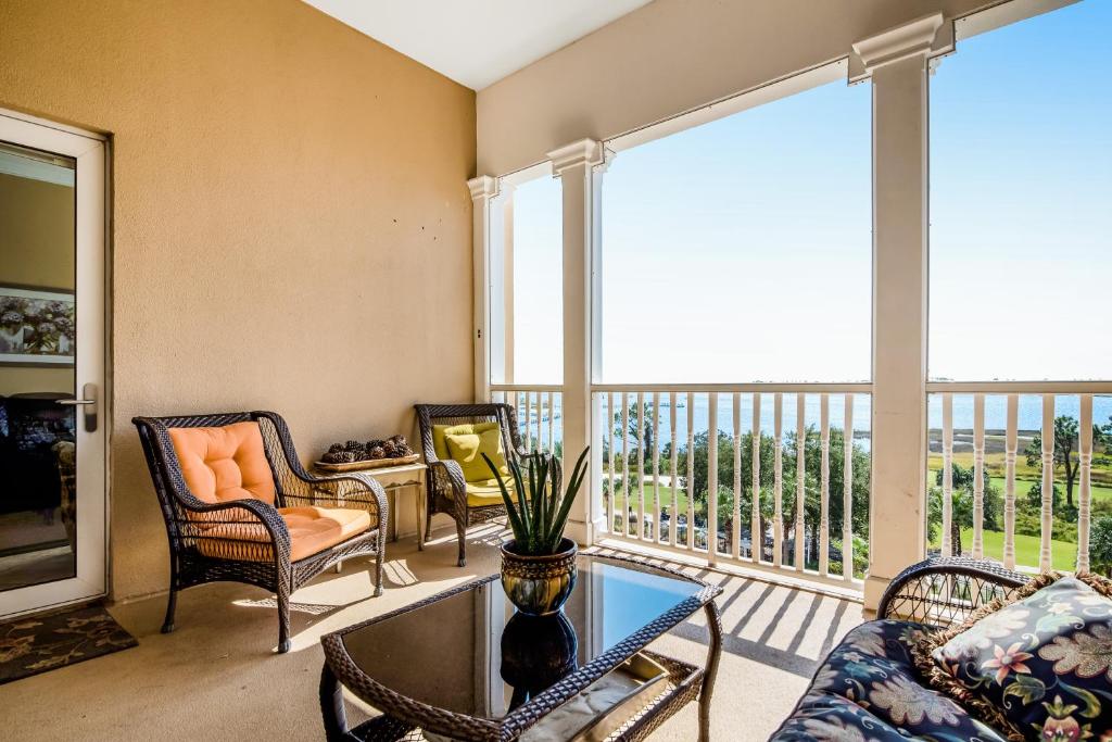sala de estar con sofá y sillas y balcón en Reflections At Bay Point 610, en Panama City Beach