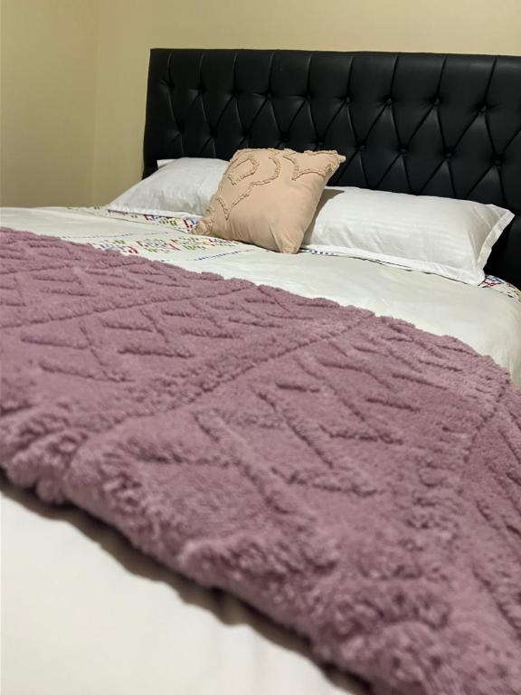 a purple blanket laying on top of a bed at Casa Aura Stays Kerugoya in Keruguya