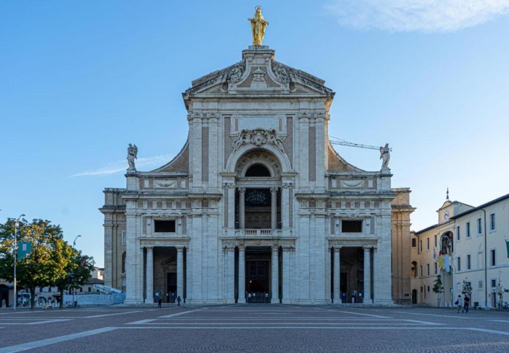 un grand bâtiment avec une statue au-dessus dans l'établissement Appartamento Pennazzi, à Santa Maria degli Angeli