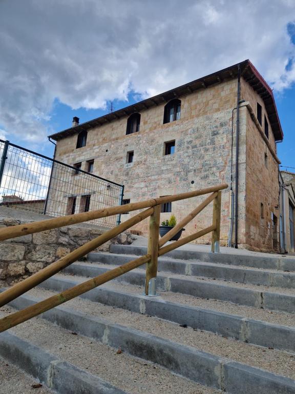 un bâtiment en briques avec quelques escaliers devant dans l'établissement Casa Rural El Pastor, à Ros