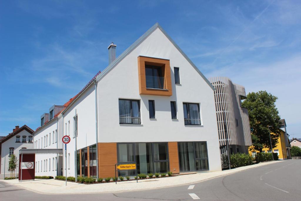 a white building on the corner of a street at Hotel WITT am See in Weiherhammer