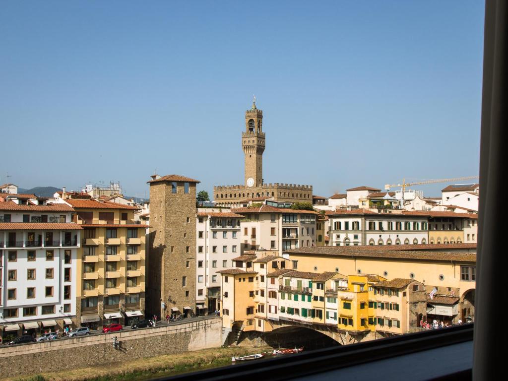 Blick auf eine Stadt mit Gebäuden und einem Uhrturm in der Unterkunft Apartments Florence - Ponte Vecchio Exclusive in Florenz