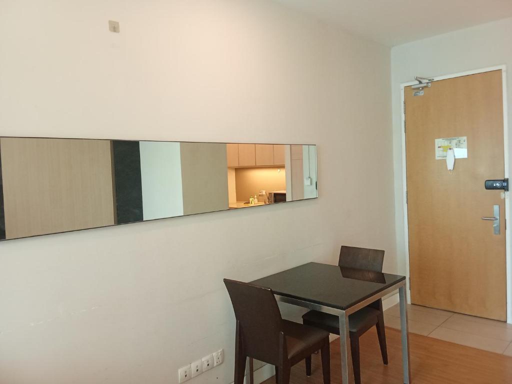una sala da pranzo con tavolo e specchio sul muro di Rizstar suite at swiss garden Residence bukit Bintang a Kuala Lumpur