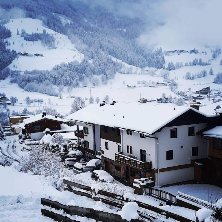 a snow covered village with buildings and a mountain at Haus Stille Oase in Bruck an der Großglocknerstraße