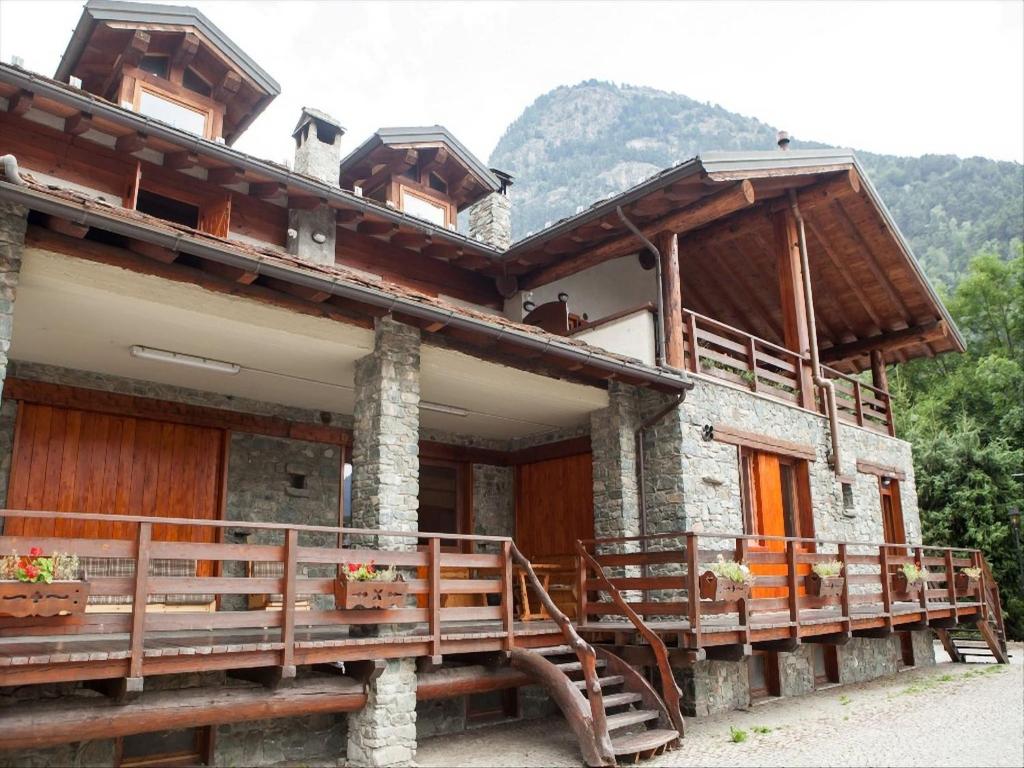 a house with a wooden deck in front of it at Apartment in Antey-Saint-André near Ski Lifts in Antey-Saint-André